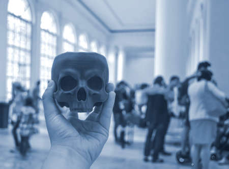 Skull printed on 3d printer in mans hand. On the back of a blurry plan - peopleの写真素材