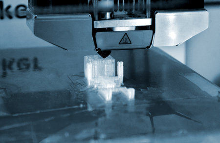 3D printer working and creating an object from the hot molten plasticの写真素材