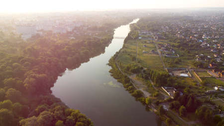 Aerial drone view flight over the river, the banks overgrown with forestの写真素材