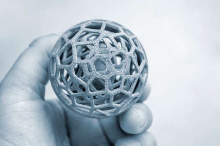 Person holding object printed on industrial professional powder 3D printer.の写真素材