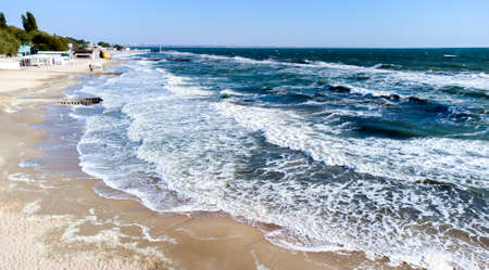 Aerial drone view flight over sea waves that roll onto sandy shore.の写真素材