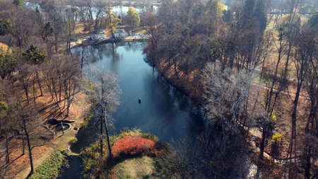 Arial drone view flight over lake in park on sunny autumn dayの写真素材