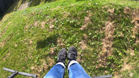 Girl rides or climbs on lift or cable car up mountain.