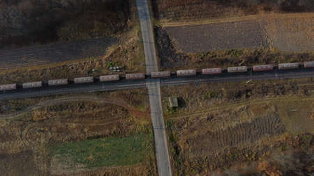 Top View Freight Train Passing Railway Crossing. Aerial Drone View Flight Overの写真素材
