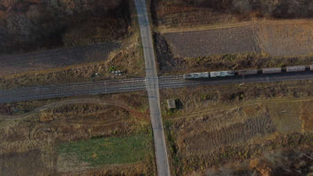 Top View Freight Train Passing Railway Crossing. Aerial Drone View Flight Overの写真素材