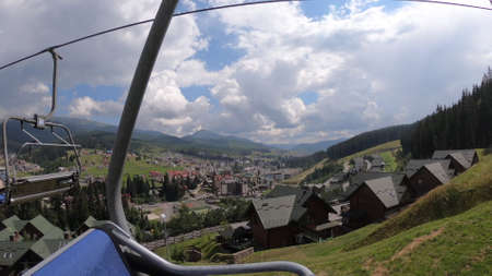 Ropeway movement in forest in mountains on sunny day. Side view.の写真素材
