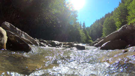 Very beautiful mountain landscape scene with flowing river and bright reflectionの写真素材