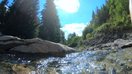 Very beautiful mountain landscape scene with flowing river and bright reflectionの写真素材