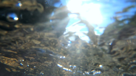 Abstract blurred background view of flowing water in river from below.の写真素材