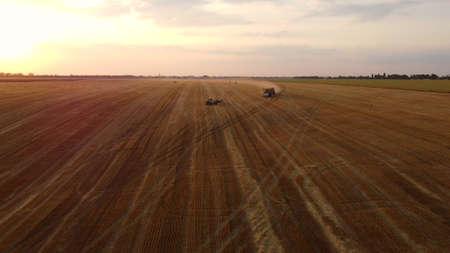 Truck loaded with haystacks drives up to tractor to load haystackの写真素材