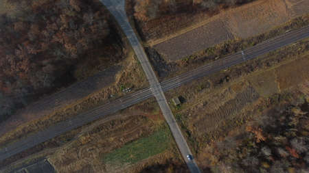 Panoramic View of Railroad Crossing Between Trees in Fields Aerial Drone Viewの写真素材