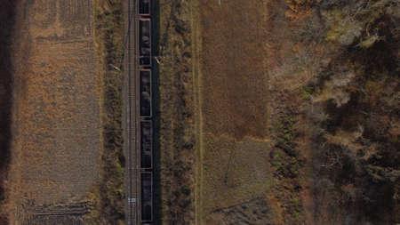 Aerial drone view flight over movement train with carriages filled coal autumnの写真素材