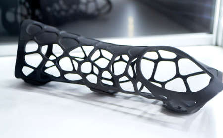 Black orthopedic plastic prosthesis printed on powder 3D printer for hand. Orthopedic gypsum helmet close-up. Multi Jet Fusion MJF 3D printing technology. New modern progressive additive technology.の写真素材