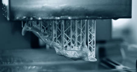Stereolithography DPL 3d printer create detail and liquid drips, platform slowly move with liquid close-up. Progressive modern additive technology 3D printing, create scaled model by UV polymerizationの写真素材