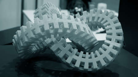 Big abstract object of blue color printed on a 3d printer on a white tableの写真素材