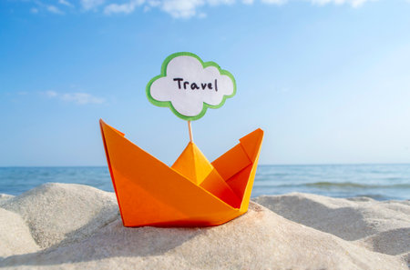 Orange Paper Boat on Sandy Seashore Close-up Small Boat from Paper on Backgroundの写真素材