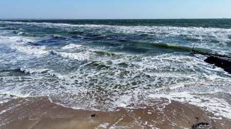 Aerial drone view flight over waves that roll onto the sandy shore. Top viewの写真素材