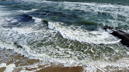 Aerial drone view flight over Beautiful sea waves on sand beach with white foamの写真素材