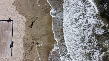 People walking and relaxing on beach on sunny day. Aerial Drone View Flight Overの写真素材