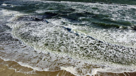 Aerial drone view flight over Beautiful sea waves on sand beach with white foamの写真素材