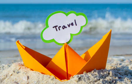 Orange Paper Boat on Sandy Seashore Close-up. Small Boat from Paperの写真素材