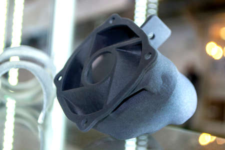 Man holding plastic model printed on powder 3d printer from polyamide powder.の写真素材