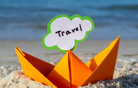 Orange Paper Boat on Sandy Seashore Close-up. Small Boat from Paperの写真素材
