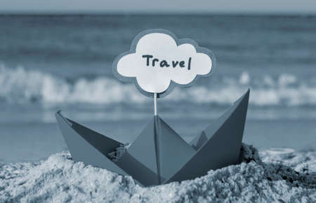 Orange Paper Boat on Sandy Seashore Close-up. Small Boat from Paperの写真素材