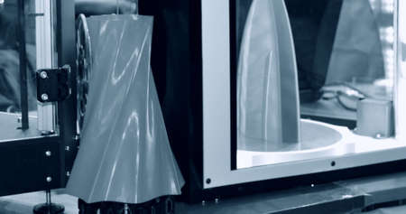 3D printer works and creates an object from the hot molten plasticの写真素材