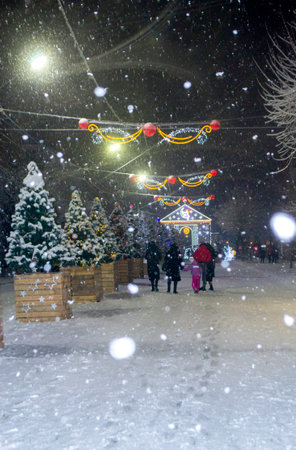 City street during snowfall at winter night.の写真素材