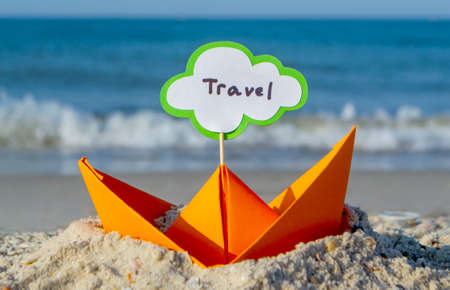 Orange Paper Boat on Sandy Seashore Close-up. Small Boat from Paperの写真素材