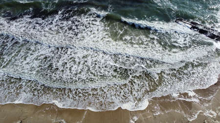 Aerial drone view flight over waves that roll onto the sandy shore. Top viewの写真素材