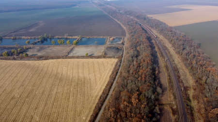 Panoramic Moving Freight Train Along Railway Tracks, Trees Agricultural Fieldsの写真素材