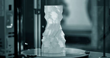 The object in the form of a blue vase stands on the desktopの写真素材