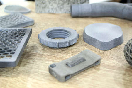 Many different models printed on 3D printer. Gray and black objects printedの写真素材