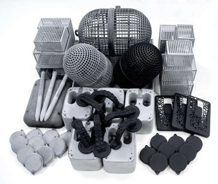 Many different models printed on 3D printer isolated on white background. Gray and black objects printed on 3D printer made of plastic close-up. Prototypes of various shapes made by 3d printerの写真素材