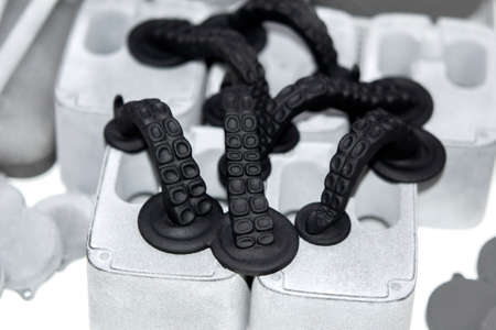 Models printed on 3D printer. Black objects octopus tentacles printed on 3D printer made of plastic close-up. Surface 3D printed models. Prototypes of shapes made by 3d printer. printing technologyの写真素材