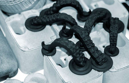 Models printed on 3D printer. Black objects octopus tentacles printed on 3D printer made of plastic close-up. Surface 3D printed models. Prototypes of shapes made by 3d printer. printing technologyの写真素材