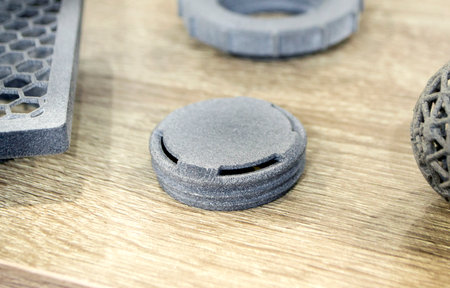 Models printed on 3D printer. Gray objects printed on 3D printer made of plastic close-up. Surface...