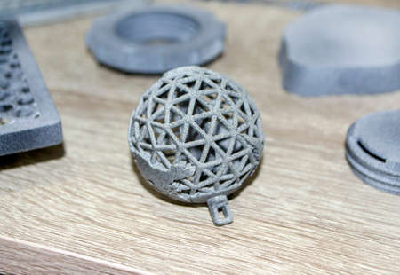Many models printed on 3D printer. Gray and black objects printed on 3D printerの写真素材