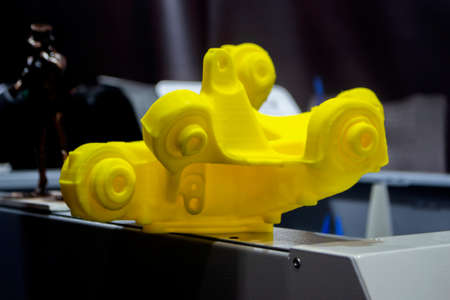 Yellow abstract 3D printed model close-up. Objects printed on 3D printer from plastic close-up. 3D printed form. Prototypes of various shape made by 3d printer. Concept new modern printing technologyの写真素材