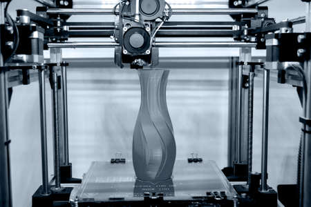Process printing model on 3d printer. High tech digital printer computer machine in action. Printing mechanism adding layers to object. FDM 3d printer working at 3d printing lab. 3D modern technology.の写真素材