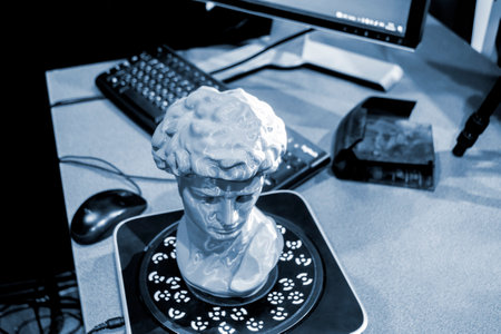 Gray human head on 3d printed close-up. An object prototype of a human head with hair printed by a 3D printer stands on a table. New modern additive 3D printing technology. Fused deposition modelingの写真素材