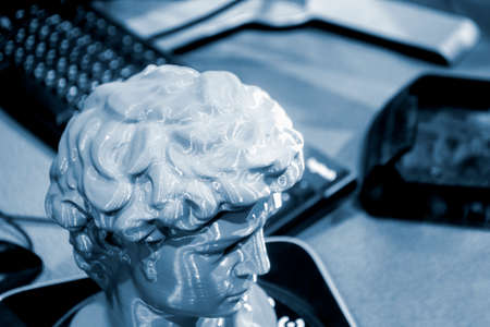 Gray human head on 3d printed close-up. An object prototype of a human head with hair printed by a...