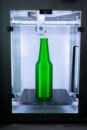 Object green bottle printed on 3D printer close-up, inside on desktop of 3d printer. Progressive modern additive technology. Concept 4.0 industrial revolution. Modern 3D printing additive technologyの写真素材