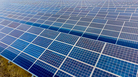 Aerial drone view flight over solar power station panels. Aerial top view of solar farm. Green energy, electrical innovation. Renewable Energy. Industrial Solar Energy Farm producing solar power.の写真素材