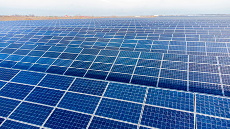 Aerial drone view flight over solar panels on sunny day close-up. Photovoltaic solar panel. Moving over solar panels with sun glare. Production of renewable alternative energy. Green ecological energyの写真素材