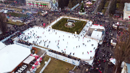 Kiev, Ukraine, January 2, 2022:-Aerial panoramic view cityscape urban park, outdoor ice skating rink and lot of people. People skating on open-air ice skating rink. Public park. New Year Christmasのeditorial素材