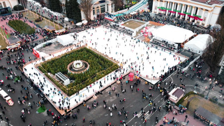 Kiev, Ukraine, January 2, 2022:-Aerial panoramic view cityscape urban park, outdoor ice skating rink and lot of people. People skating on open-air ice skating rink. Public park. New Year Christmasのeditorial素材