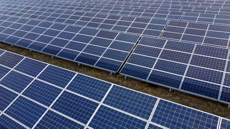 Aerial drone view flight over solar power station panels. Aerial top view of solar farm. Green energy, electrical innovation. Renewable Energy. Industrial Solar Energy Farm producing solar power.の写真素材